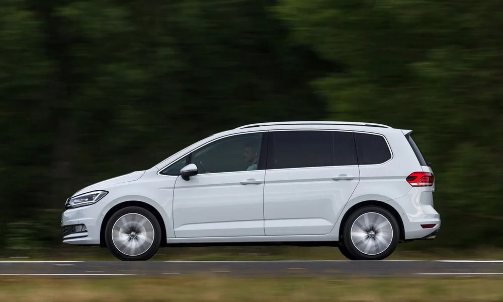 Фото Volkswagen Touran — вид сбоку, фото 3. Белый кузов в профиль — пропорции, высота посадки и дизайн дисков. Длинная база — простор второго ряда; короткие свесы упрощают парковку Volkswagen Touran — вид сбоку, фото 3