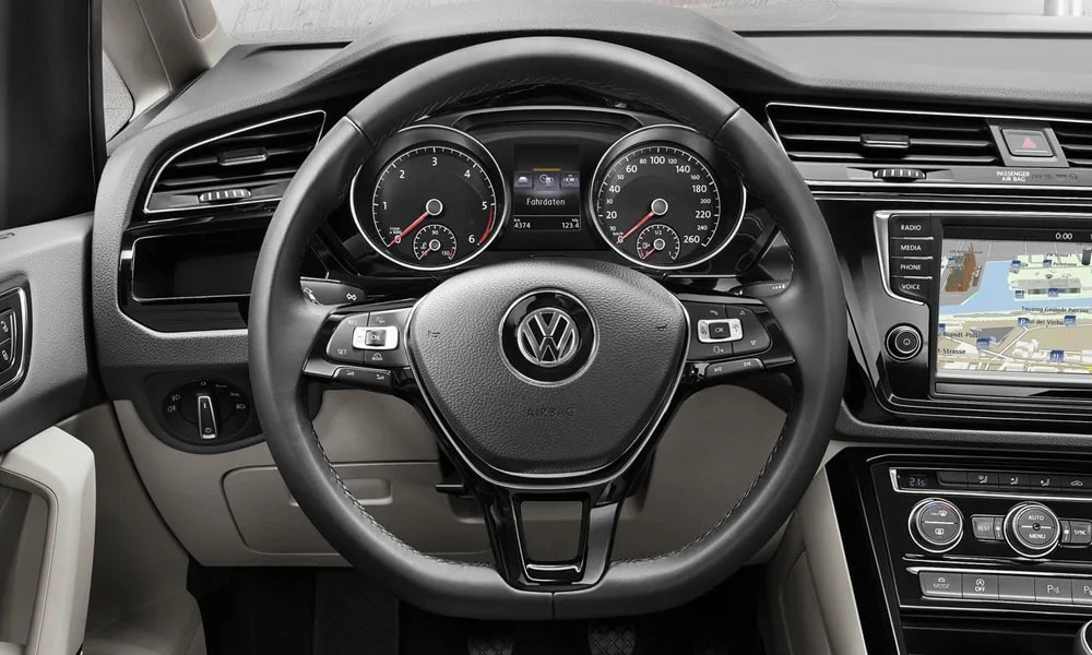 Фото Volkswagen Touran — руль. Обшивка обода и компоновка спиц крупным планом. Клавиши на спицах управляют медиа, круизом и ассистентами — руки остаются на руле Volkswagen Touran — руль