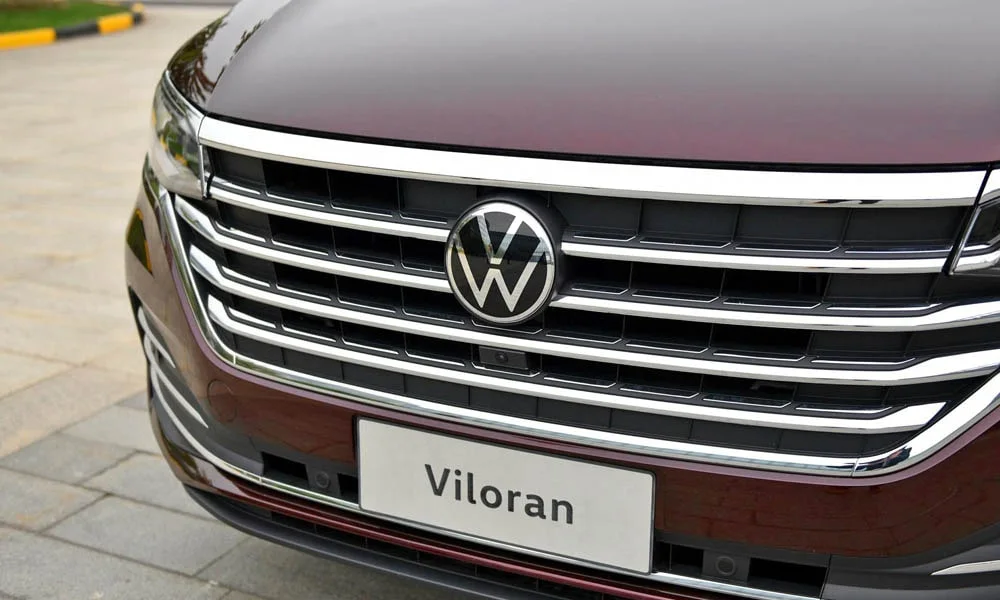 Фото Volkswagen Viloran (2024) — решётка радиатора. Фирменный рисунок облицовки — визитная карточка марки. Активные жалюзи за решёткой закрываются на трассе ради аэродинамики — есть у ряда моделей Volkswagen Viloran (2024) — решётка радиатора