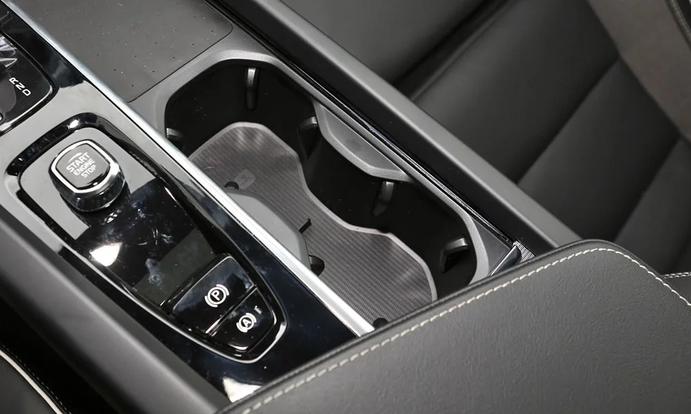 Фото Volvo V60 Cross Country (2024) — центральная консоль. Подстаканники и ниши для мелочей между креслами. Прорезиненное дно ниш удерживает мелочи в поворотах Volvo V60 Cross Country (2024) — центральная консоль