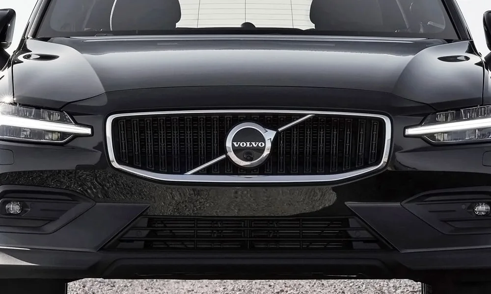 Фото Volvo V60 Cross Country (2024) — вид спереди, фото 4. Чёрный кузов, строгая симметрия оптики — базовый ракурс знакомства с дизайном. Рисунок ходовых огней — подпись модели, по нему её узнают в потоке Volvo V60 Cross Country (2024) — вид спереди, фото 4