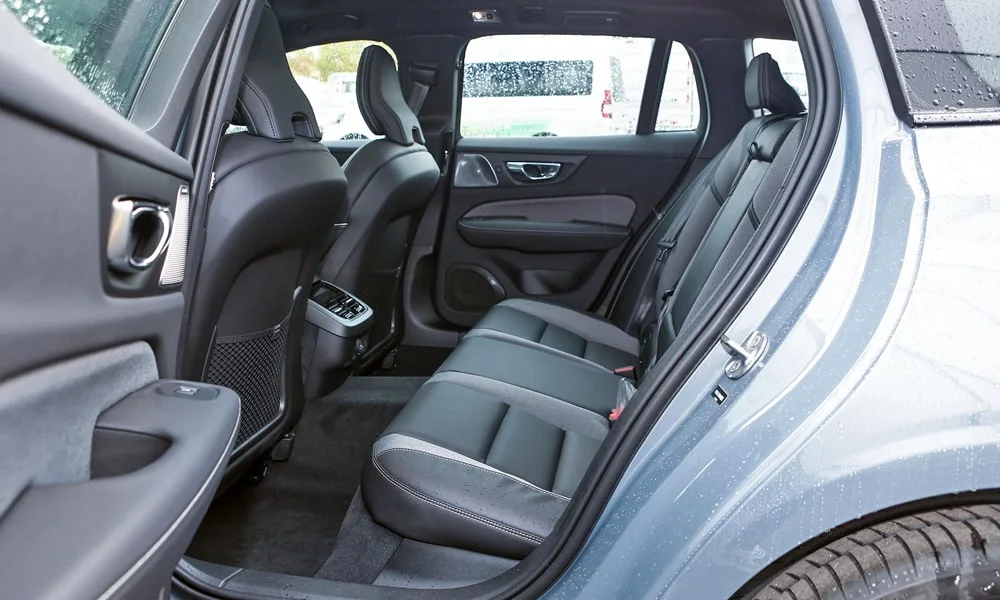 Фото Volvo V60 Cross Country (2024) — задние сиденья. Посадка второго ряда: подголовники и подлокотник. Плоский пол упрощает посадку втроём Volvo V60 Cross Country (2024) — задние сиденья
